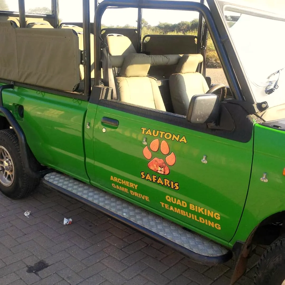 A Tautona game vehicle, its door painted with archery, game drive, quad biking and team building