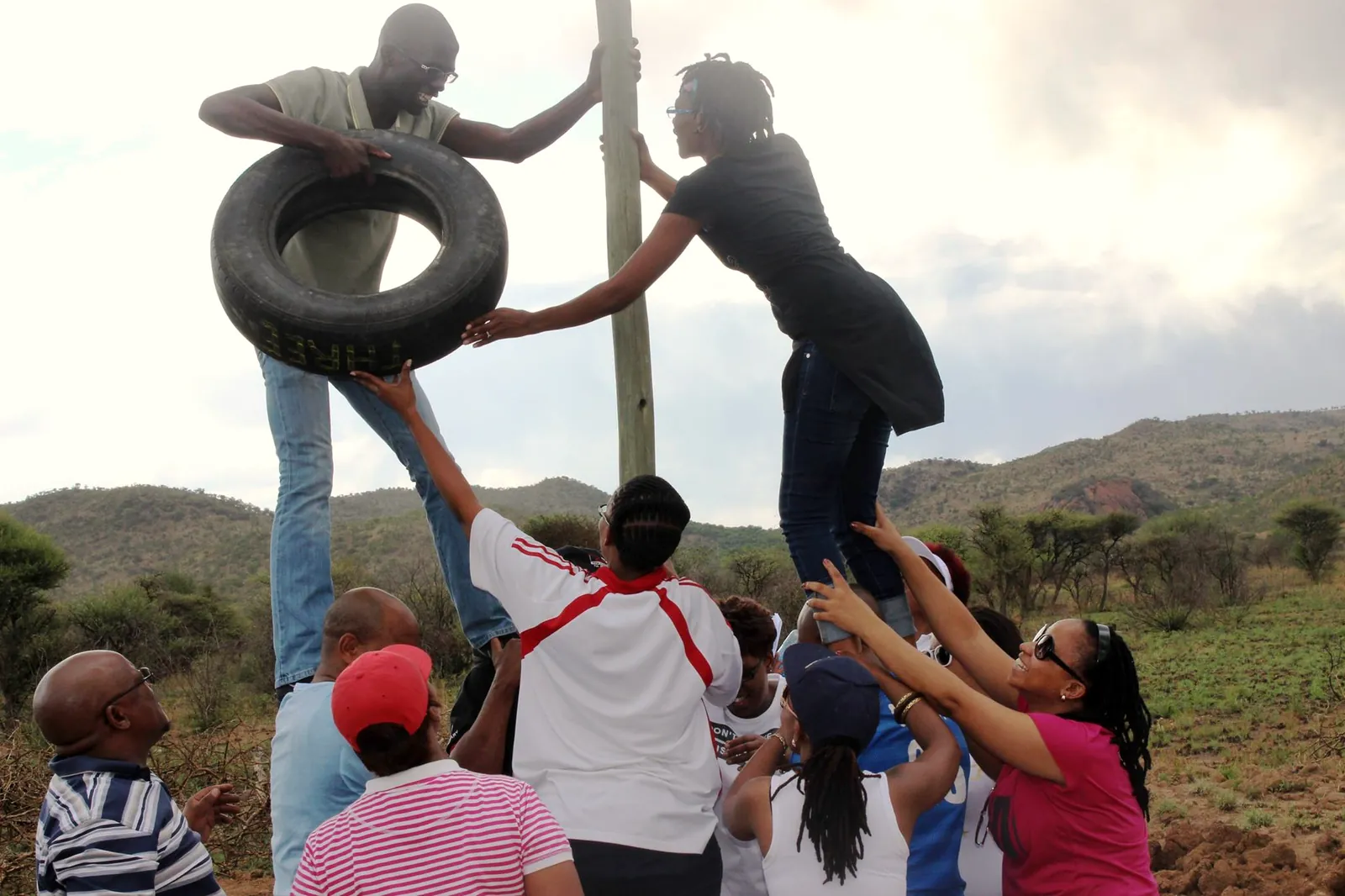 A team lifting a tyre over a pole in the Giant Finger challenge