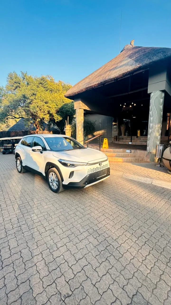 A Tautona transfer vehicle at a lodge entrance at golden hour