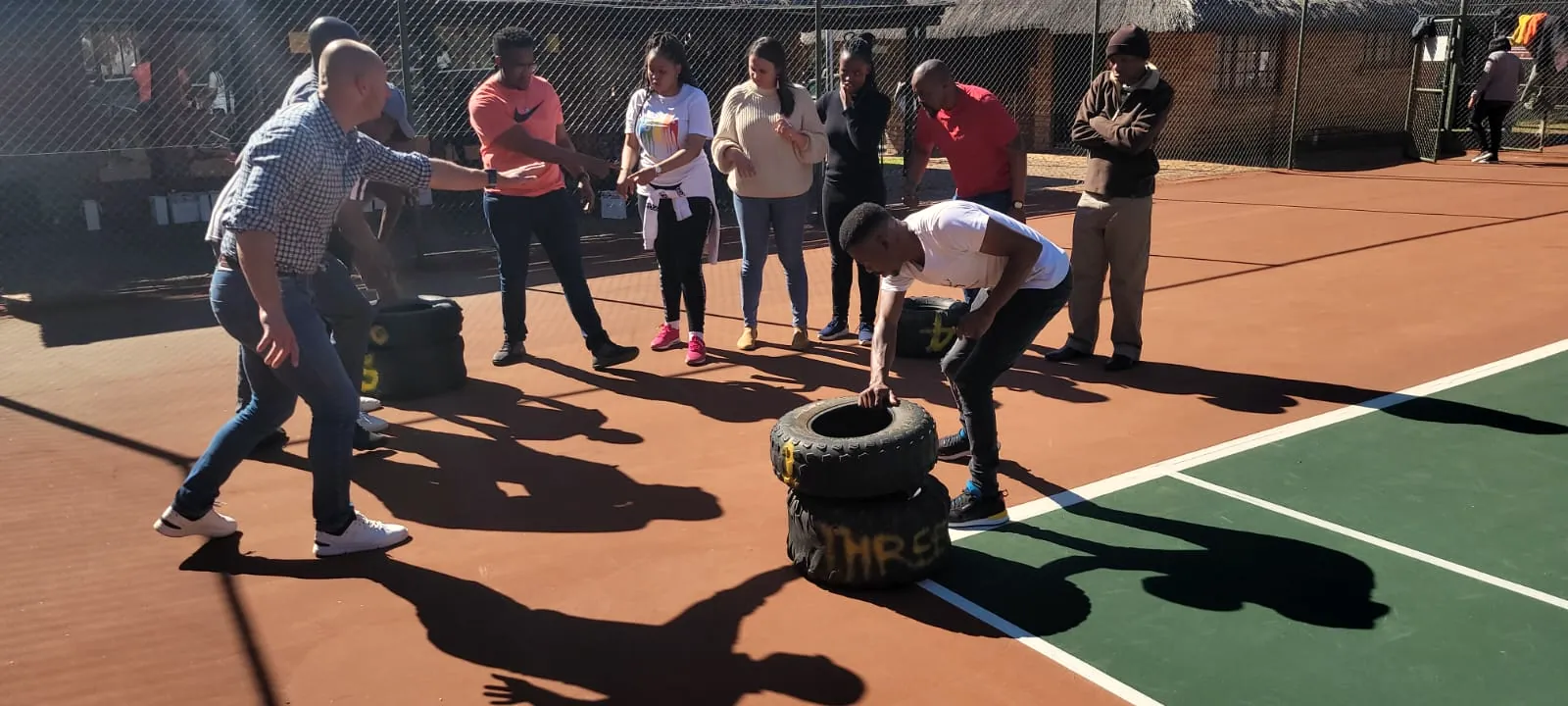 Team moving tyres across a court